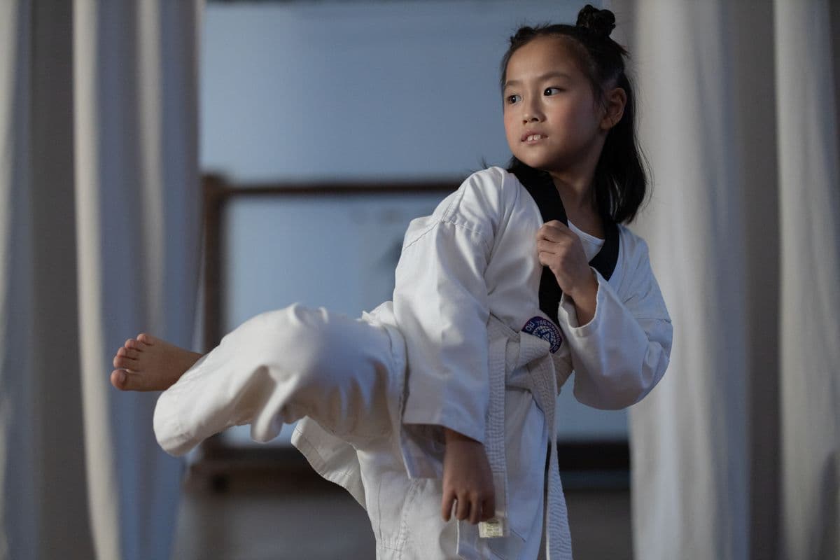 A taekwondo athlete mid-air during a high kick